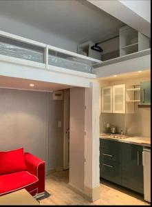 salon z czerwonym krzesłem i kuchnią w obiekcie Grand studio centre Cannes w Cannes