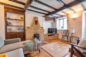 a living room with a stone fireplace and a couch at Finest Retreats - Westcote Cottage in Bradwell