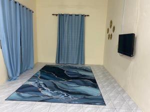 a room with a blue rug on the floor at iena homestay in Kampong Bongaliu