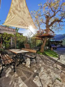 un tavolo da picnic con sedie, un albero e una terrazza in legno di Haus Nothnagl a Spitz