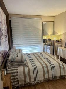 a bedroom with a bed and a window with a blind at Résidence Saint Tropez in Saint-Tropez