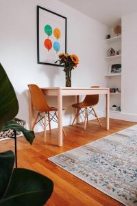 een eettafel met stoelen en een vaas met bloemen bij Albion Cottage central Falmouth with parking and 10 minutes to the beach in Falmouth