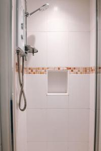 a shower with a shower head in a bathroom at Albion Cottage central Falmouth with parking and 10 minutes to the beach in Falmouth