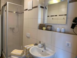 a white bathroom with a sink and a shower at Appartment Strandstraße 29 Wohnung Nr. 16 in Trassenheide +13 photos