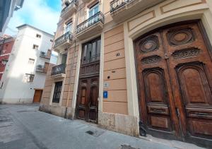 twee houten deuren aan de zijkant van een gebouw bij VALOLA Boutique Rooms in Valencia