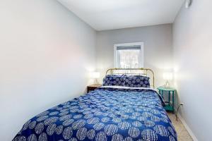 een slaapkamer met een blauw bed en een raam bij Hidden Gem in Cavendish