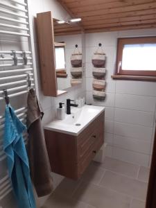 y baño con lavabo y espejo. en Landhof Kützin Ferienhaus 4 Meise, 