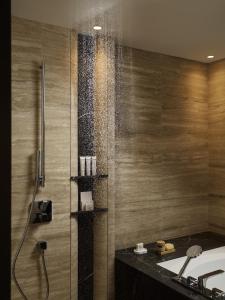 a bathroom with a shower with a bath tub at City of Dreams Mediterranean - Integrated Resort, Casino & Entertainment in Limassol