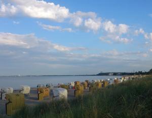 - une rangée de chaises sur une plage près de l'eau dans l'établissement Maris Ferienwohnung Nr 46, à Scharbeutz