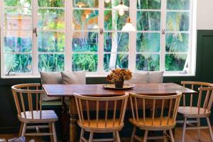uma sala de jantar com mesa, cadeiras e janelas em Cozy Renovated Vintage Modern House Downtown! em Fort Myers