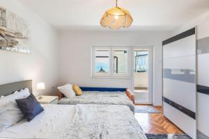 1 Schlafzimmer mit 2 Betten und einem Kronleuchter in der Unterkunft Delux Sandy Beach (Duće) in Duće