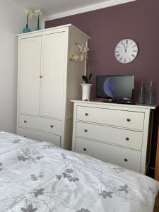 a bedroom with a bed and a dresser and a clock at Appartment Strandstraße 29 Wohnung Nr. 16 in Trassenheide