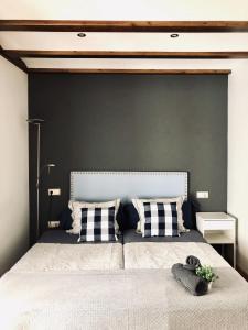 a bedroom with a large bed with a black wall at La Porticada in Morella