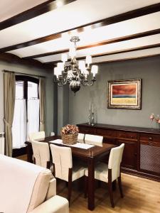 a dining room with a wooden table and white chairs at La Porticada in Morella