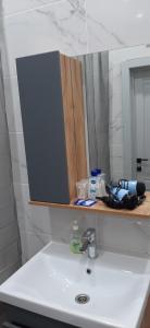 a bathroom with a sink with a mirror and a sink at Просторная однушка в центре города in Aktobe