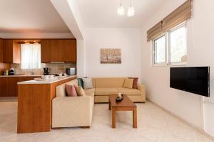 een woonkamer met een bank en een keuken bij Reni Garden House in Afantou
