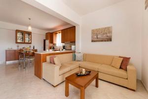 een woonkamer met een bank en een tafel bij Reni Garden House in Afantou