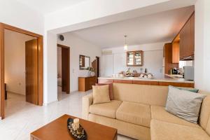 een woonkamer en keuken met een bank en een tafel bij Reni Garden House in Afantou +22 foto's