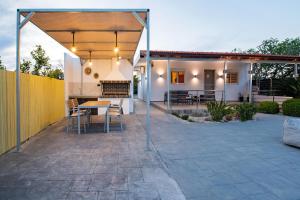 een terras met een tafel en stoelen voor een huis bij Reni Garden House in Afantou