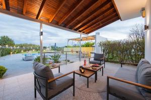 een patio met stoelen en een tafel op een dak bij Reni Garden House in Afantou