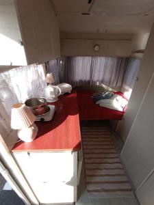 um pequeno quarto com duas mesas e uma cama em Przyczepa Niewiadów Surf Wioska em Jastarnia