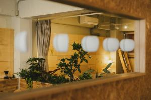 a reflection of a kitchen in a mirror at DENCHI TOKYO - Guest House DENCHI in Tokyo
