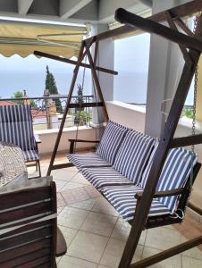 a porch swing with a view of the ocean at Niki House in Volos