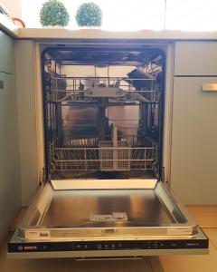 an dishwasher with dishes in it in a kitchen at Exklusive Familienappartments Zugspitze in Garmisch-Partenkirchen