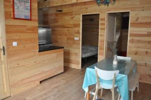ein Esszimmer mit einem Tisch und einer Küche in der Unterkunft La cabane in Saint-Laurent-de-Médoc