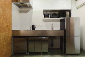 eine Küche mit einer Spüle und einem Kühlschrank in der Unterkunft DENCHI TOKYO - Guest House DENCHI in Tokio