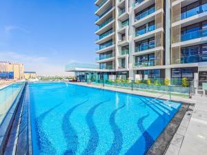 una gran piscina frente a un edificio en Charming Condo With Balcony Near Dubai Hills Park, en Dubái