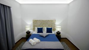 - une chambre avec un lit bleu et deux lampes dans l'établissement Casa do Marquês, à Vidigueira