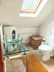 a bathroom with a glass sink and a toilet at Rural retreat near Knock in Ballyhaunis