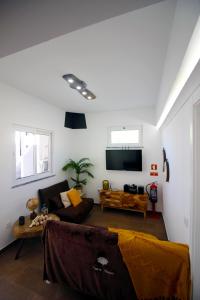 a living room with a couch and a tv at Casa do Marquês in Vidigueira