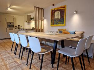 Villa Op de Voort (XL, 12-22 personen) في اوسدان-زولده: غرفة طعام مع طاولة وكراسي خشبية