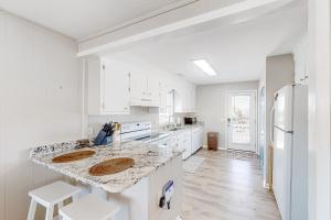 a kitchen with white cabinets and a marble counter top at HB261 Rosie's Rendezvous in Holden Beach +22 photos