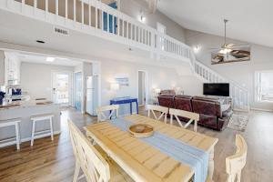 a dining room and living room with a table and chairs at HB261 Rosie's Rendezvous in Holden Beach