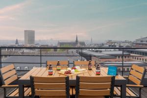 een tafel met flessen bier en eten op een balkon bij Sweet Inn - Waterloo in Brussel