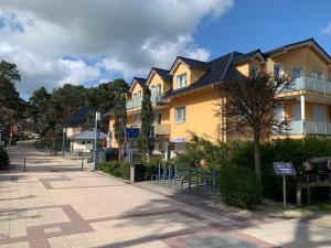 a large yellow building on the side of a street at Appartment Strandstraße 29 Wohnung Nr. 16 in Trassenheide