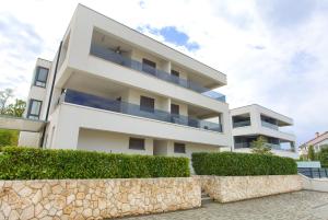 a white building with bushes in front of it at Luxury apartments Aronia in Vantačići