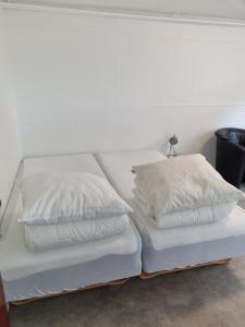 2 weiße Betten nebeneinander in der Unterkunft Feriehuse Hvide Sande in Hvide Sande