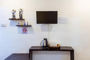 a table with a tv on a white wall at Pai Residence Hotel in Chiang Mai