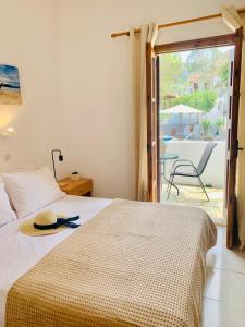 a bedroom with a bed with a hat on it at Skopelos Inn in Stafylos +37 photos