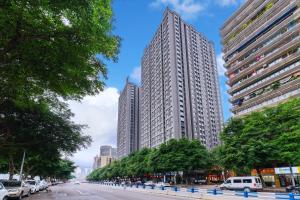 dwa wysokie budynki na ulicy miejskiej z samochodami w obiekcie Yue Ke Apartment - Changbin Road Branch w mieście Chongqing