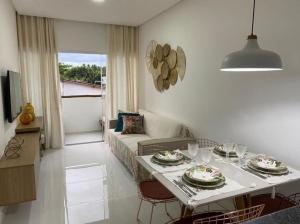 ein Wohnzimmer mit einem Tisch und einem Sofa in der Unterkunft Apartamento na Massagueira, 3km Praia do Francês in Marechal Deodoro