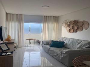 - un salon avec un canapé et une table dans l'établissement Apartamento na Massagueira, 3km Praia do Francês, à Marechal Deodoro