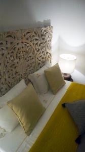 a bedroom with a bed with pillows and a lamp at Casa do Marquês in Vidigueira