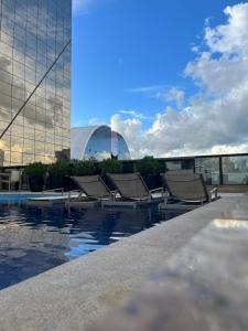 Una fila de sillones junto a un edificio. en Hotel Cullinan Deluxe, en Brasilia