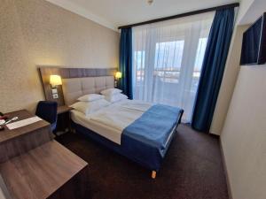 ein Hotelzimmer mit einem Bett, einem Schreibtisch und einem Fenster in der Unterkunft Medos Hotel in Budapest