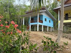 a blue house with a balcony and flowers at 2 Bed Sunset Seaview Good View House B in Ko Yao Noi